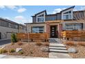 Modern townhome featuring a unique facade, landscaped front yard, and inviting entryway with stylish door and accents at 12843 W Nevada Pl, Lakewood, CO 80228