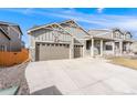 Charming exterior features a welcoming front porch, well-maintained lawn, and a three car garage at 2187 Pineywoods St, Mead, CO 80542