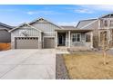 Charming exterior features a welcoming front porch, well-maintained lawn, and a three car garage at 2187 Pineywoods St, Mead, CO 80542
