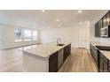 Modern kitchen with large island, stainless appliances, sleek cabinetry, and hardwood floors at 39816 Floyd St, Elizabeth, CO 80107