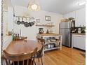 Bright kitchen with white cabinets, wooden floors, stainless steel appliances, and a wooden dining table at 1390 N Emerson St # 406, Denver, CO 80218