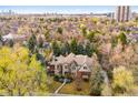 Stunning aerial view of the beautiful home nestled amongst mature trees in a peaceful neighborhood at 17 Polo Club Dr, Denver, CO 80209