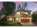 Charming two-story home with a well-manicured lawn and a two-car garage in a quiet neighborhood at sunset at 301 Widgeon Ln, Longmont, CO 80503