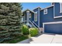 Charming two-story home with blue siding, white trim, well-manicured lawn, and an attached two-car garage at 104 Willowick Cir, Highlands Ranch, CO 80129