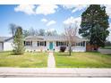 Charming single-story home boasts a bright, modern exterior with a well-manicured lawn and inviting turquoise front door at 986 S Jersey St, Denver, CO 80224