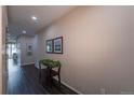 Inviting hallway with hardwood floors, neutral wall paint, decorative accents, and natural light at 915 N Waterloo Ct, Aurora, CO 80018