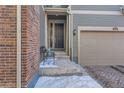 Front entrance with steps, bench, and dark-colored door at 9308 Inca Dove Cir, Littleton, CO 80125