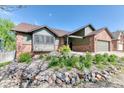 Beautiful home exterior featuring brick accents, mature landscaping, and a stone retaining wall at 13830 Silverton Dr, Broomfield, CO 80020