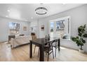 Bright dining area featuring a contemporary light fixture, adjacent to a large bay window at 2205 E 25Th, Denver, CO 80205