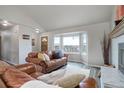 Comfortable living room with a cozy fireplace, bay windows, and stylish wood flooring at 10510 Inspiration Dr, Parker, CO 80138