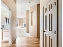 Bright hallway featuring hardwood floors, leading to a living room with a fireplace at 1978 Granger Cir, Castle Rock, CO 80109