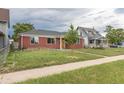Street-level view of single story brick home and small tree in the yard at 4453 Fillmore St, Denver, CO 80216