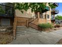 Close-up of the building entrance stairs with black iron railings and xeriscaped landscape at 3299 Lowell Blvd # 204, Denver, CO 80211