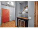 Welcoming entryway boasts a red door, wood floors, beverage cooler, and industrial style light fixture at 3299 Lowell Blvd # 204, Denver, CO 80211