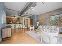 Cozy living room with kitchen view, open layout, exposed ductwork, and brick wall accents at 3299 Lowell Blvd # 204, Denver, CO 80211