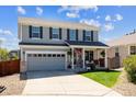 Charming two-story home features a well-manicured lawn, grey siding, and a welcoming front porch at 11866 High Desert Rd, Parker, CO 80134