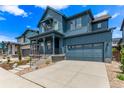 Beautiful blue two-story home with a covered porch and two-car garage on a sunny day at 5608 Grandville Ave, Longmont, CO 80503