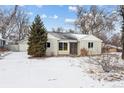 Charming single-story home with an attached garage and a well-maintained front yard, all covered in fresh snow at 7135 W 24Th Ave, Lakewood, CO 80214