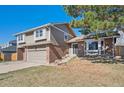 Attractive home boasts brick accents, mature landscaping, and a driveway leading to an attached garage at 5429 S Waco St, Centennial, CO 80015