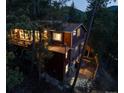 Two-story home with large windows and exterior patio surrounded by mature trees at 9506 S Deer Creek Canyon Rd, Littleton, CO 80127