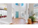 Bright, spacious foyer featuring unique brick flooring design, a blue front door and an abundance of natural light at 9804 N Crystal Lake Dr, Littleton, CO 80125