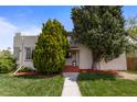 Home's attractive front facade with a neat yard and mature trees at 1400 S Knox Ct, Denver, CO 80219
