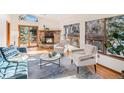 Bright living room featuring a stone fireplace, hardwood floors, and large windows for natural light at 837 Meadow Run, Golden, CO 80403