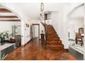 Inviting foyer with terracotta tile flooring, arched doorways, and a wrought iron staircase at 1795 N Monaco St Pkwy, Denver, CO 80224