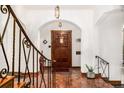 Inviting entryway features terracotta flooring, wrought iron railing, and a solid wood door at 1795 N Monaco St Pkwy, Denver, CO 80224