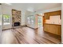 Bright living room with stone fireplace, built-in shelves, and wood-look floors at 13598 E Asbury Dr, Aurora, CO 80014