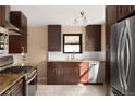Modern kitchen featuring stainless steel appliances, granite countertops, and dark wood cabinetry at 424 S Leyden St, Denver, CO 80224