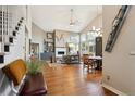 Open-concept living room with hardwood floors, a cozy fireplace, and high ceilings creating an airy atmosphere at 1913 Five Iron Dr, Castle Rock, CO 80104