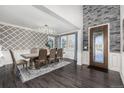 Elegant dining room featuring dark wood floors, a decorative chandelier, and stone accent wall at 2627 Hillcroft Ln, Castle Rock, CO 80104