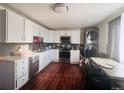 Well-lit kitchen with white cabinets, stainless steel appliances, and a dining area at 5411 Chandler Way, Denver, CO 80239