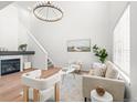 Bright living room with vaulted ceiling, fireplace, modern chandelier, and neutral decor at 1129 W 112Th Ave # C, Denver, CO 80234