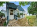 Side view of the home's front exterior, showing a fenced yard and quaint design at 1200 Newark St, Aurora, CO 80010