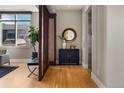 Bright entryway featuring hardwood floors, console table, mirror, and elevator access at 2800 E 2Nd Ave # 202, Denver, CO 80206