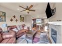Open-concept living room showcasing a fireplace, leather sofa and view into the kitchen at 1000 Elmhurst Dr # B, Highlands Ranch, CO 80129