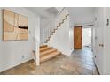 Inviting entryway with tiled flooring and a staircase leading to the upper level at 7076 S Spruce W Dr, Centennial, CO 80112