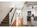 Bright foyer featuring wood floors, a staircase, and views into the living spaces at 16706 E Black Horn Dr, Parker, CO 80134