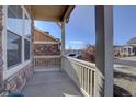 Inviting covered porch featuring stone accents and a view of the neighborhood street at 3164 S Kirk Way, Aurora, CO 80013