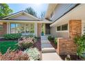 Inviting front entrance with stone steps, colorful landscaping, and a glimpse of the home's architectural details at 4626 E Links Dr, Centennial, CO 80122