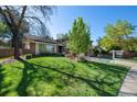 Landscaped front lawn, mature trees, and a glimpse of the home's exterior, creating a welcoming curb appeal at 4626 E Links Dr, Centennial, CO 80122
