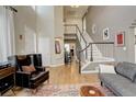 Elegant living room with a soaring ceiling, a striking staircase, and plenty of natural light at 10259 Fairgate Way, Highlands Ranch, CO 80126