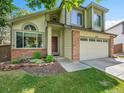 Charming two-story home with lush green lawn, mature trees, and two-car garage at 1052 Northampton Ct, Highlands Ranch, CO 80126