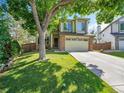 Charming two-story home with lush green lawn, mature trees, and two-car garage at 1052 Northampton Ct, Highlands Ranch, CO 80126