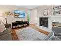 Bright living room with fireplace, hardwood floors, and comfortable furnishings at 7049 E Briarwood Cir, Centennial, CO 80112