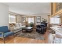 Inviting living room with hardwood floors, plush rug, and comfortable furnishings at 9942 Lane St, Thornton, CO 80260