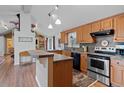 Kitchen with oak cabinetry, tile backsplash, stainless appliances, and a breakfast bar at 96 Greeley Blvd, Palmer Lake, CO 80133