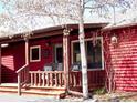 Cozy porch with wood railings, chairs, and exterior log siding at 96 Greeley Blvd, Palmer Lake, CO 80133